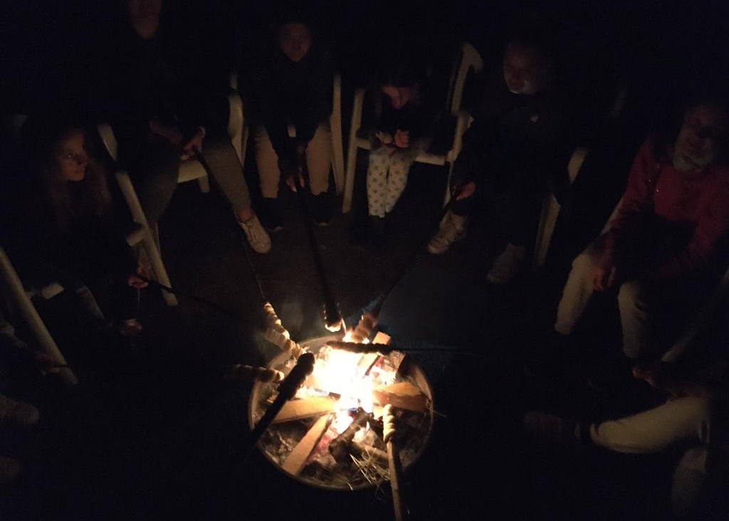 Stockbrot wird über ein Lagerfeuer gehalten