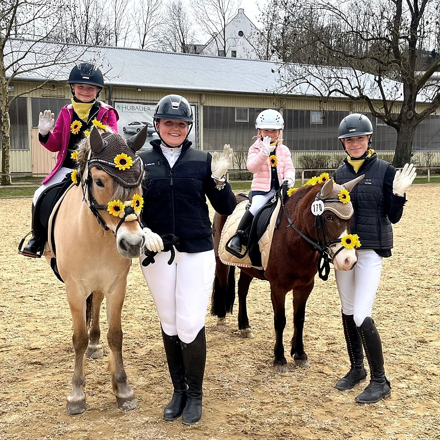 Zwei kleine Kinder sitzen auf geschmückten Ponys