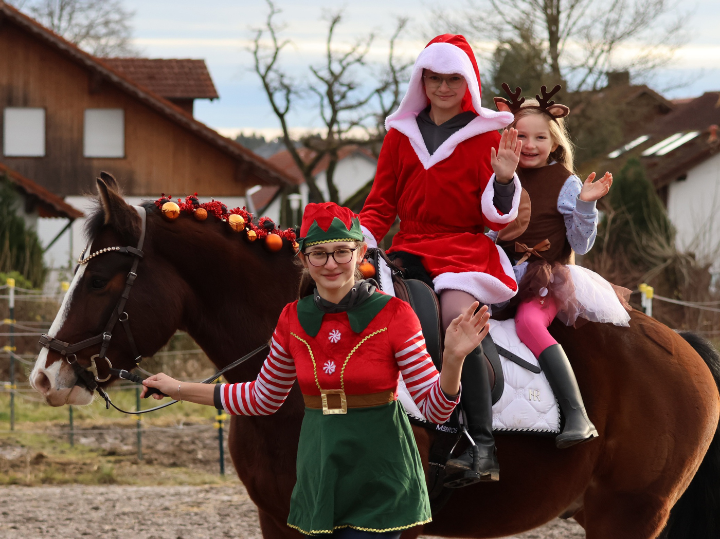 Zwei weihnachtlich verkleidete Mädchen sitzen auf einem verkleideten Pferd