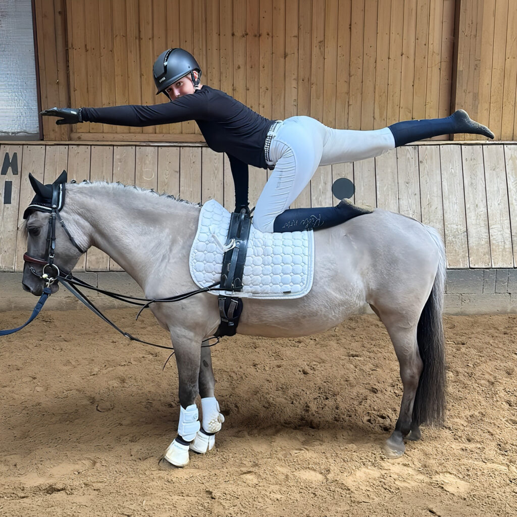 Eine Frau macht eine Turnübung auf einem Pony